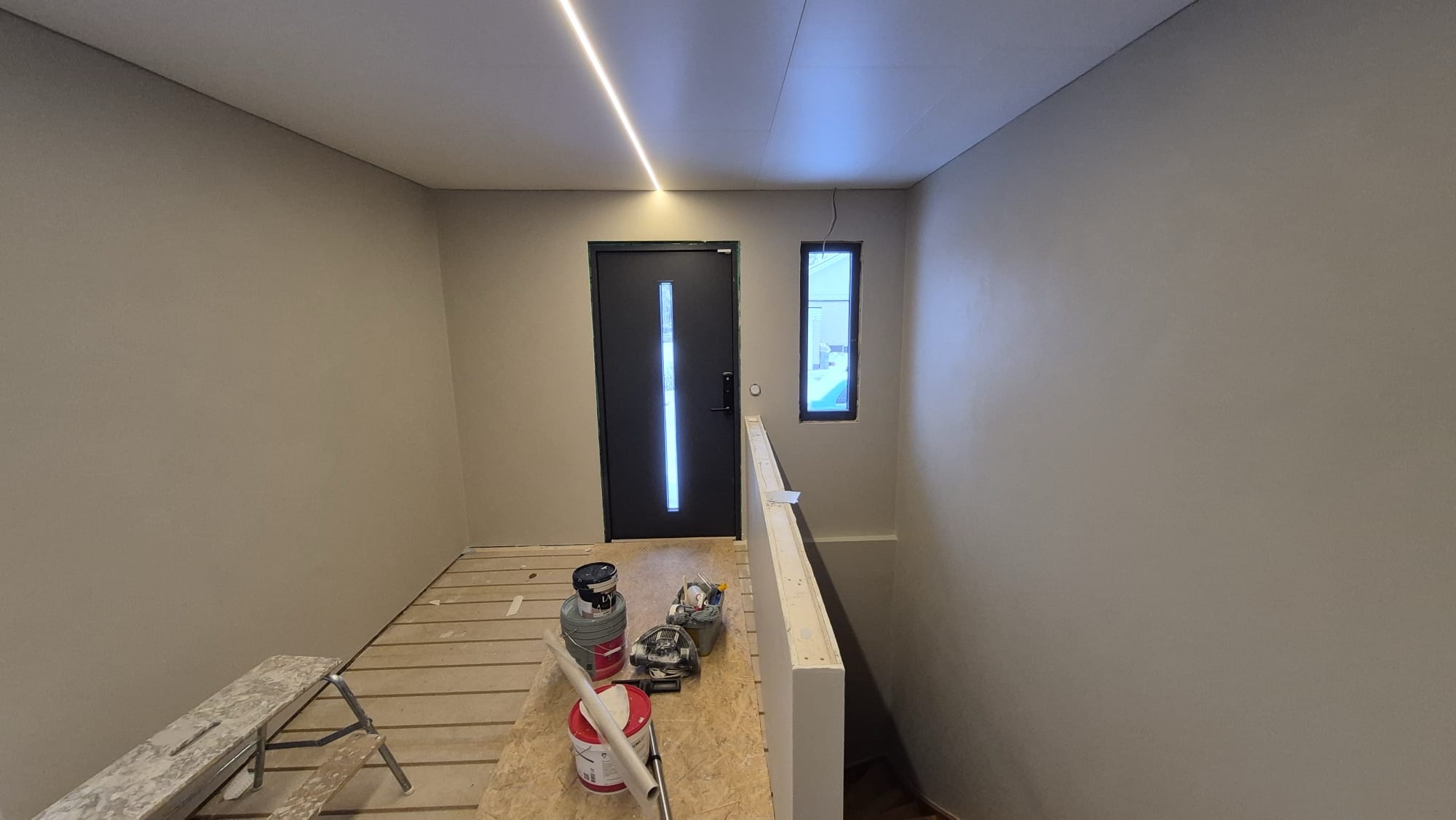 Samma hall efter målning i varm beige kulör med vitt tak