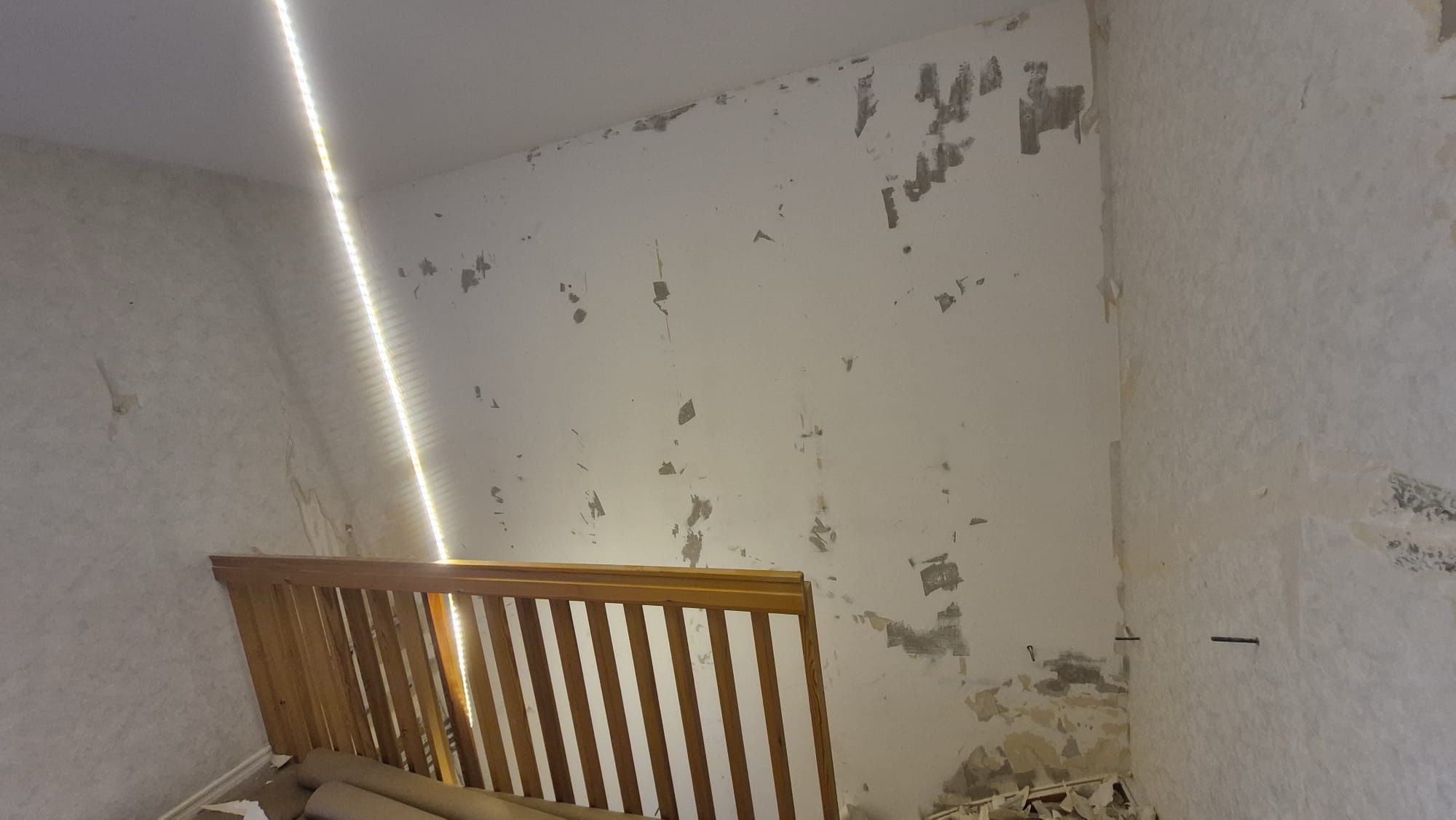 Trapphusvägg före renovering med nedriven tapet och spackel